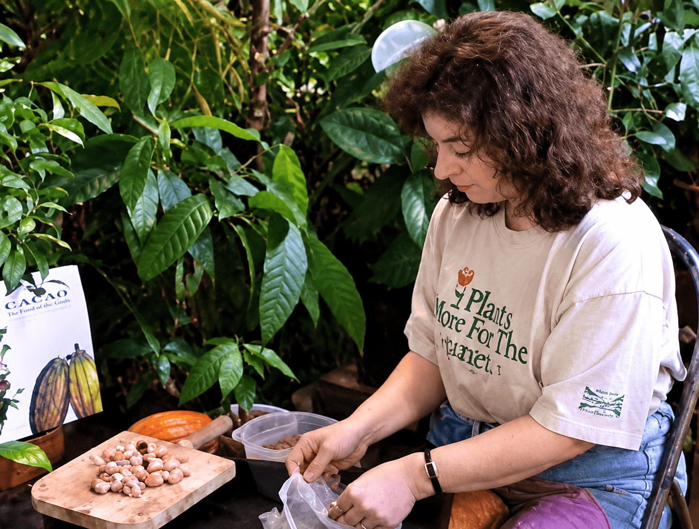 Sheri Ann Richerson processing cacao seeds surrounded by tropical foliage